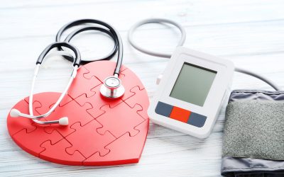 White electric tonometer with stethoscope on wooden table